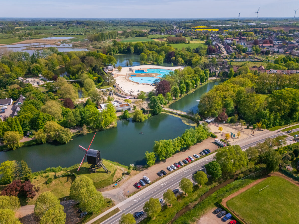 Breed luchtfoto-overzicht van De Halve Maan in Diest vanuit de verte, met de omliggende bomen en een gedeelte van de ringweg van Diest, gefotografeerd door Bert Beckers.